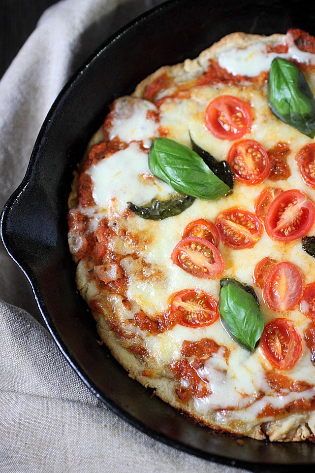 The classic Pizza Margherita.... In a skillet! This lip-smacking thin crust pizza is adorned with a quick homemade tomato sauce, chewy mozzarella cheese combined with a bit of nutty Parmesan, fresh basil, and grape tomatoes. Pizza night  just got tastier! www.mind-over-batter.com