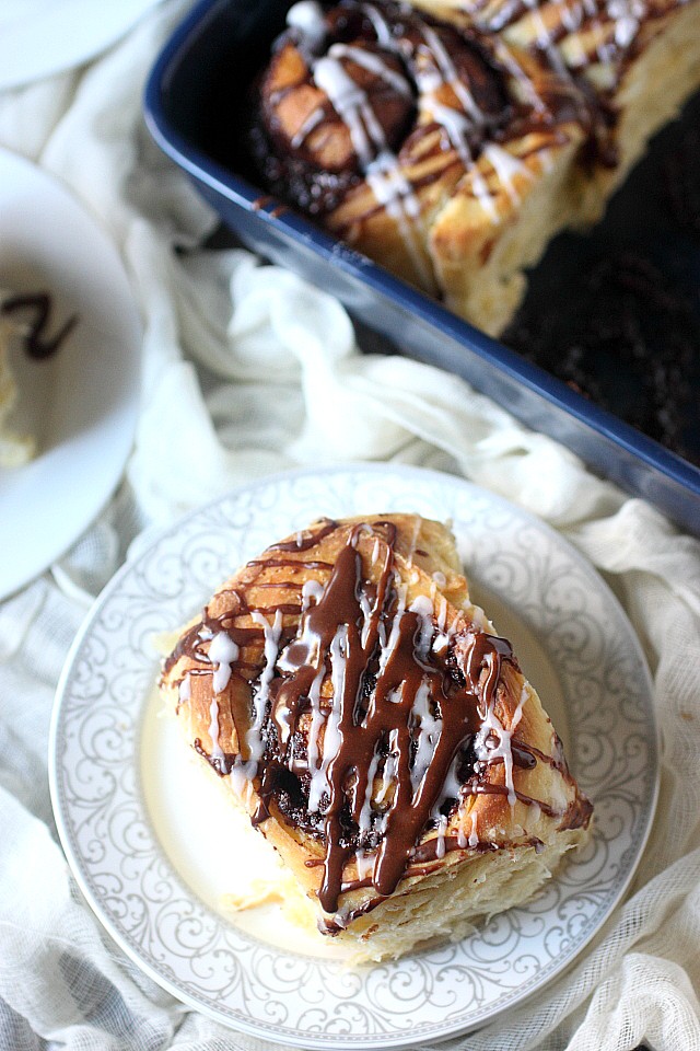 These are the BEST Chocolate Breakfast Rolls EVER! Super fluffy and a treat to bite into – These rolls are filled with a sweet chocolate filling and are liberally drizzled with a cocoa glaze! Perfect for an indulgent breakfast! www.mind-over-batter.com