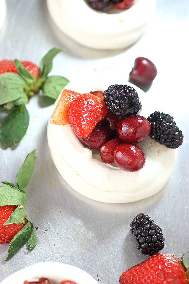 Impress your friends with these Mini Mixed Berry Pavlovas! Mini mounds of vanilla bean flavored meringue are piled with lightly sweetened berries. So pretty and so easy to make! www.mind-over-batter.com