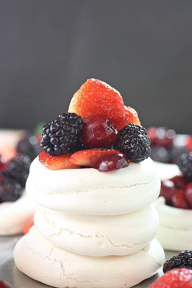Impress your friends with these Mini Mixed Berry Pavlovas! Mini mounds of vanilla bean flavored meringue are piled with lightly sweetened berries. So pretty and so easy to make! www.mind-over-batter.com